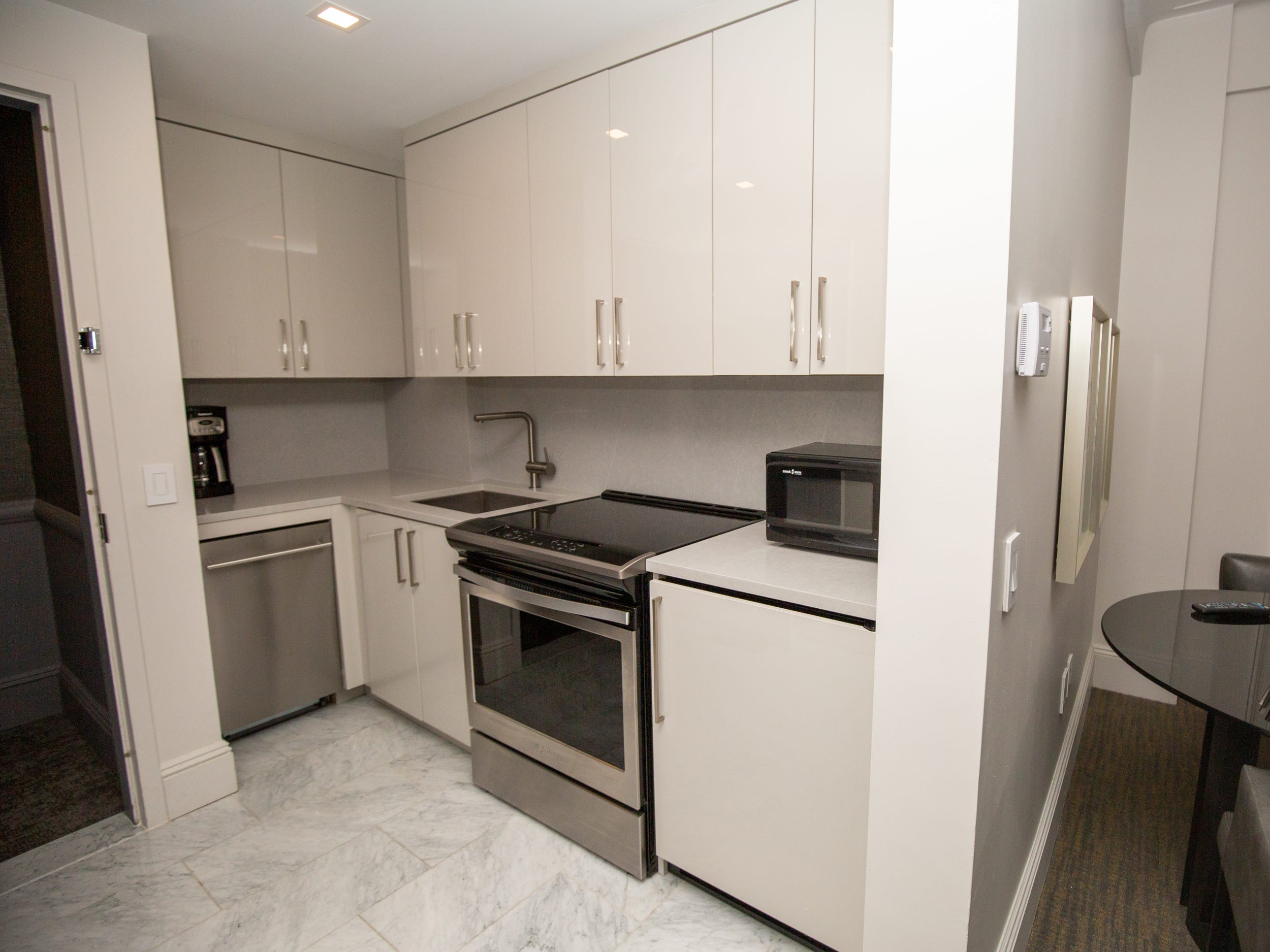 The kitchen with an oven, stove, microwave, sink, and cabinets inside a suite at AKA Central Park.